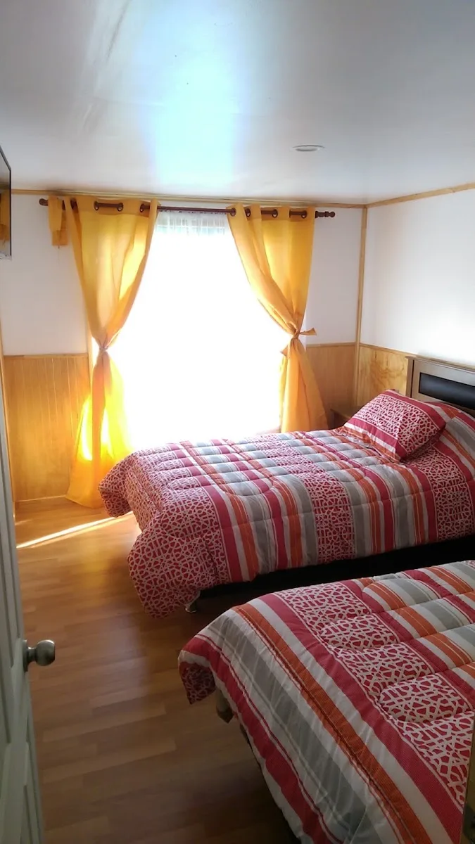 Habitación doble de Residencial Juanita con camas y cortinas amarillas