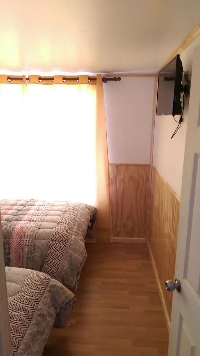 Habitación de Residencial Juanita con cama y televisor mural