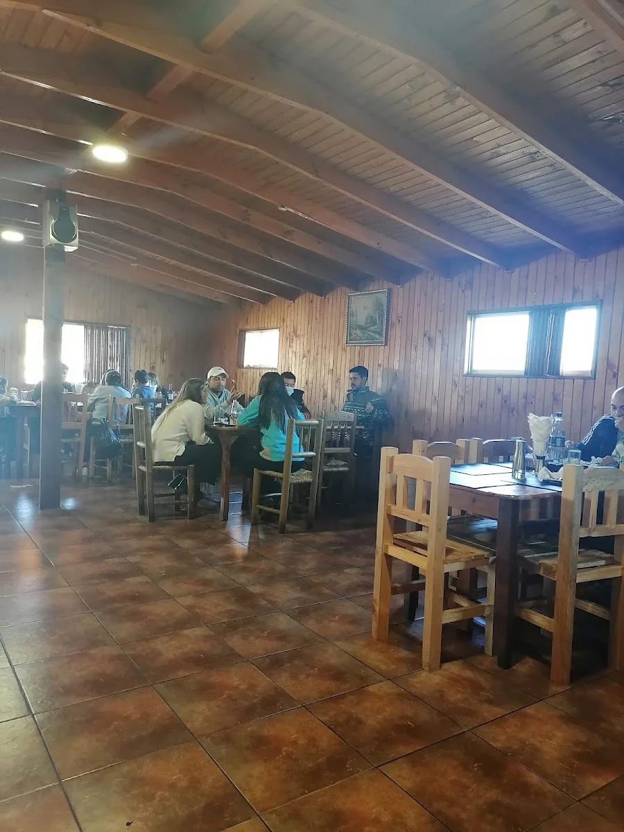 Comedor de madera con chimenea, vigas rusticas y mesas listas
