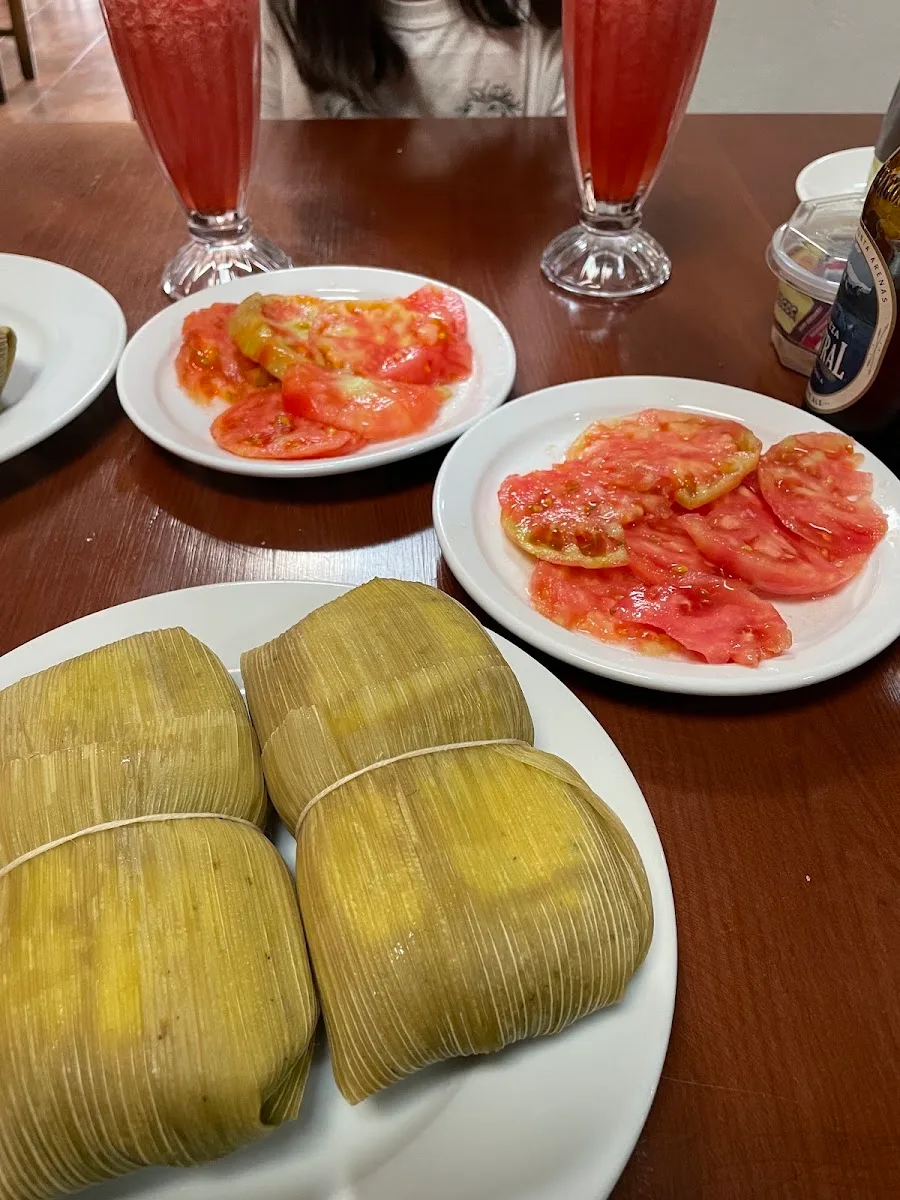 Humitas con ensalada de tomate y vasos de la casa