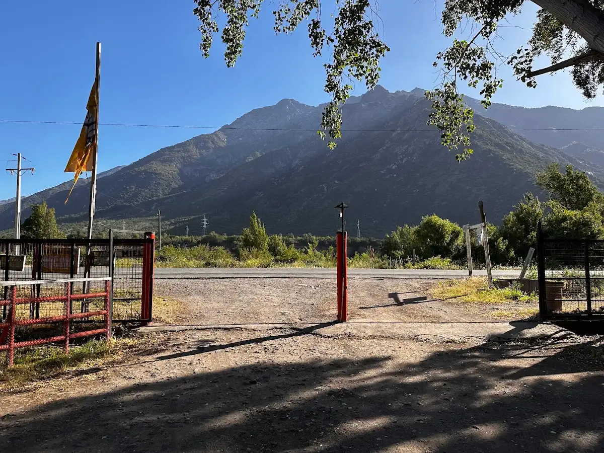 Portón de entrada a Las Parcelas de la Suiza con la cordillera al fondo