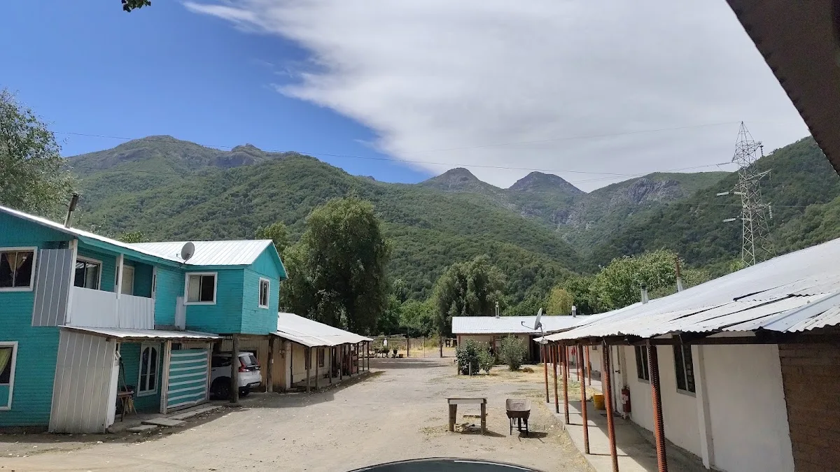 Calle interior del predio entre casas de madera con cerros verdes al fondo
