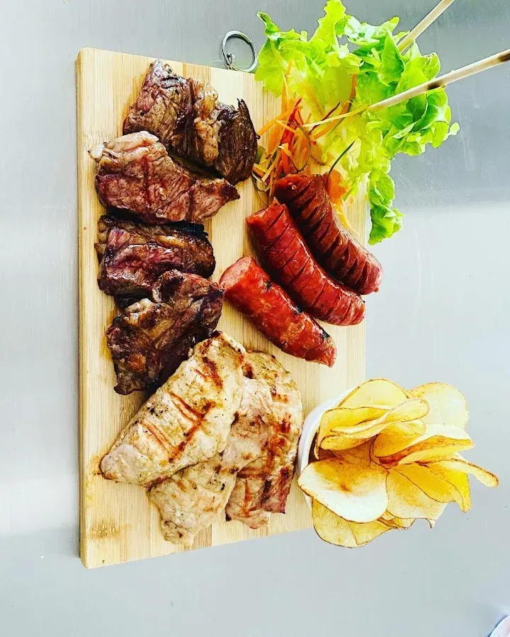 Tabla de carnes a la parrilla con longaniza, pollo y papas rústicas