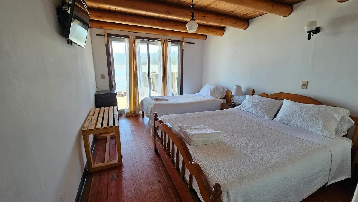 Habitación de la Hostería Miramar con camas y ventana al mar