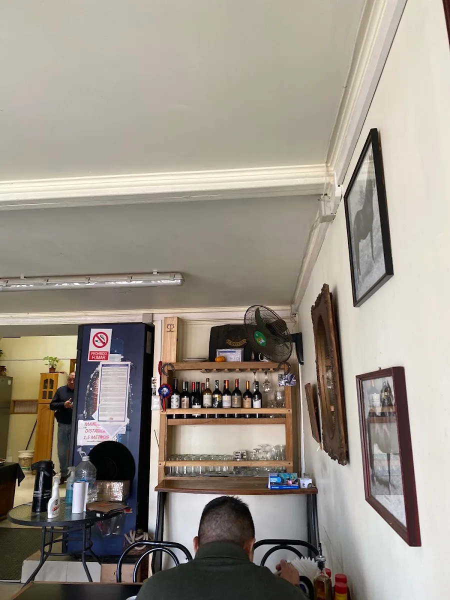 Repisa de la barra con vinos y loza colgada