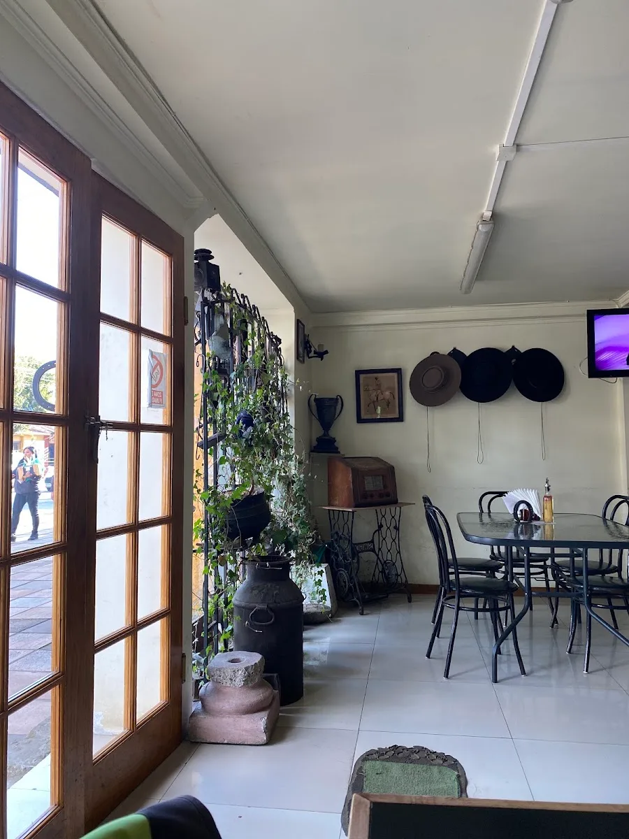 Entrada de Restaurante Neuquén en San Clemente: puerta de madera y vidrio entre plantas