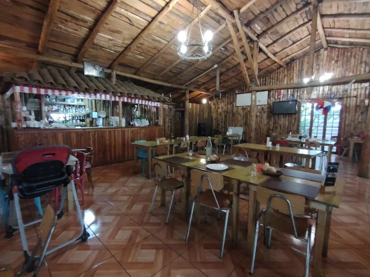 Comedor amplio de madera con vigas a la vista y banderines
