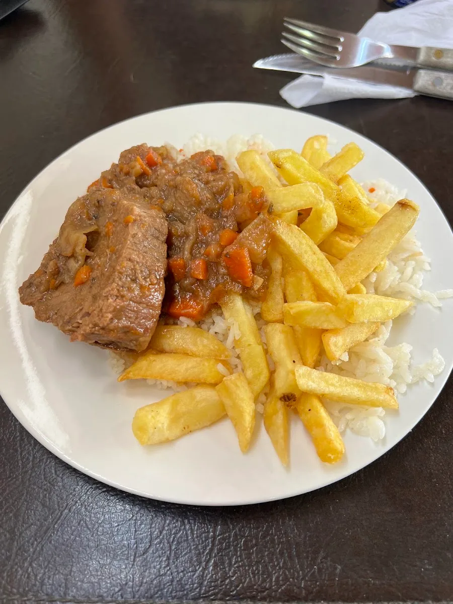 Carne al jugo con arroz y papas fritas servida en la terraza