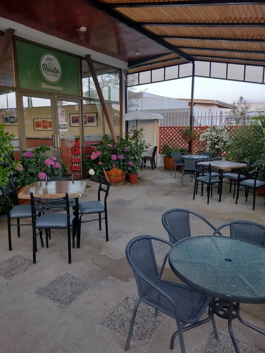 Terraza techada de Rosita con mesas y el letrero de bienvenida