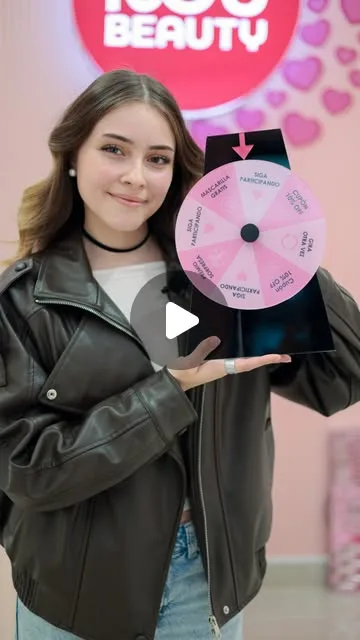 Clienta de Rou Beauty girando la ruleta de premios de los sábados frente al logo de la tienda