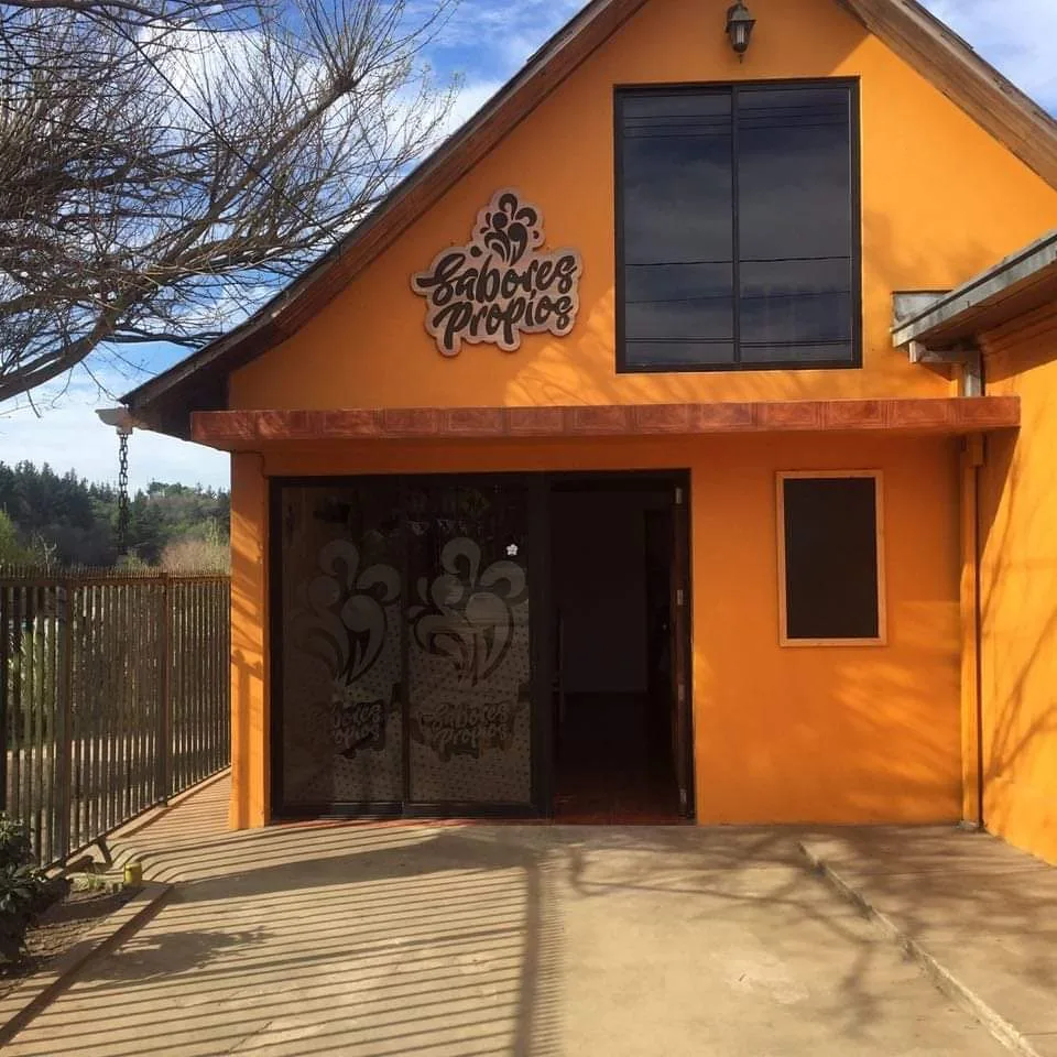 Fachada naranja de Sabores Propios en O'Higgins, Empedrado, con el logo pintado a mano sobre la entrada