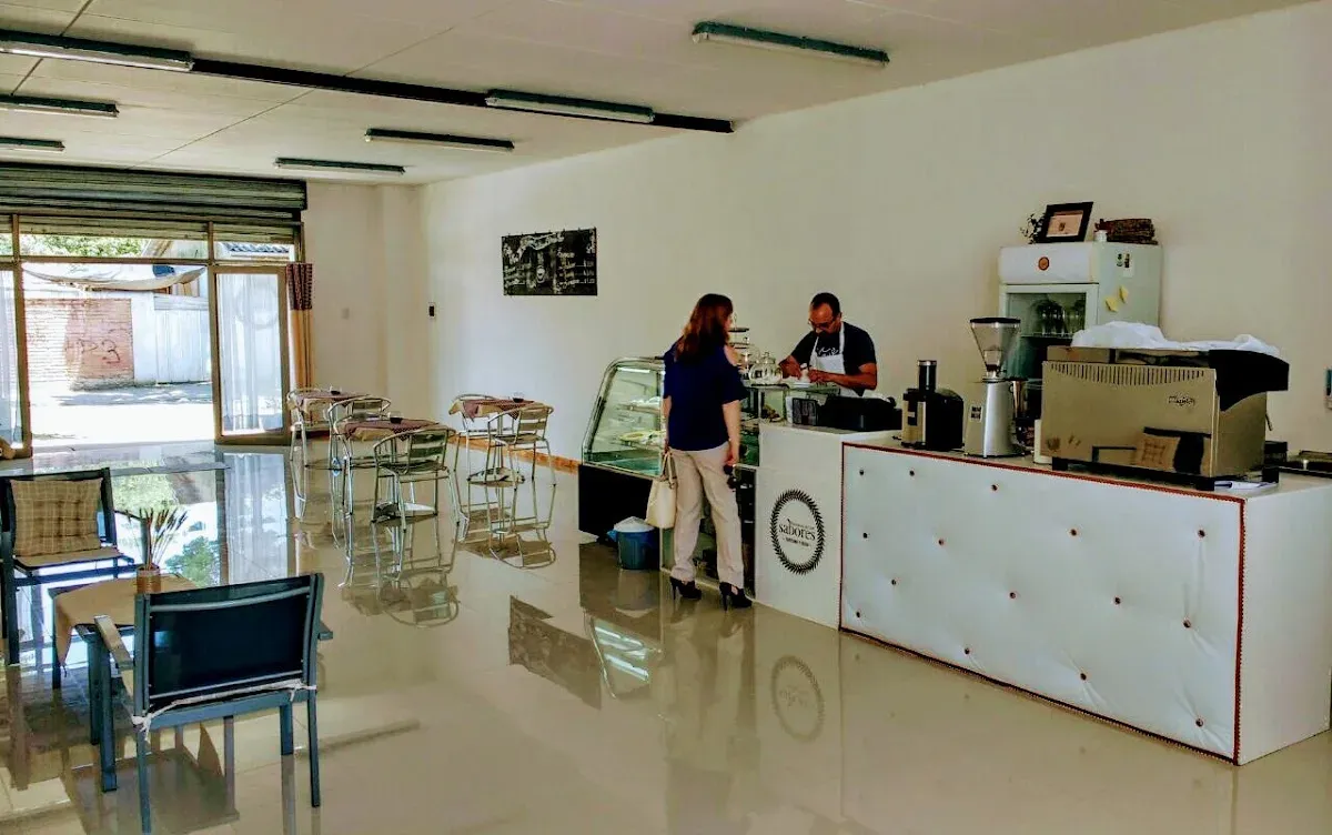 Interior de la cafetería Sabores con la barra con el logo