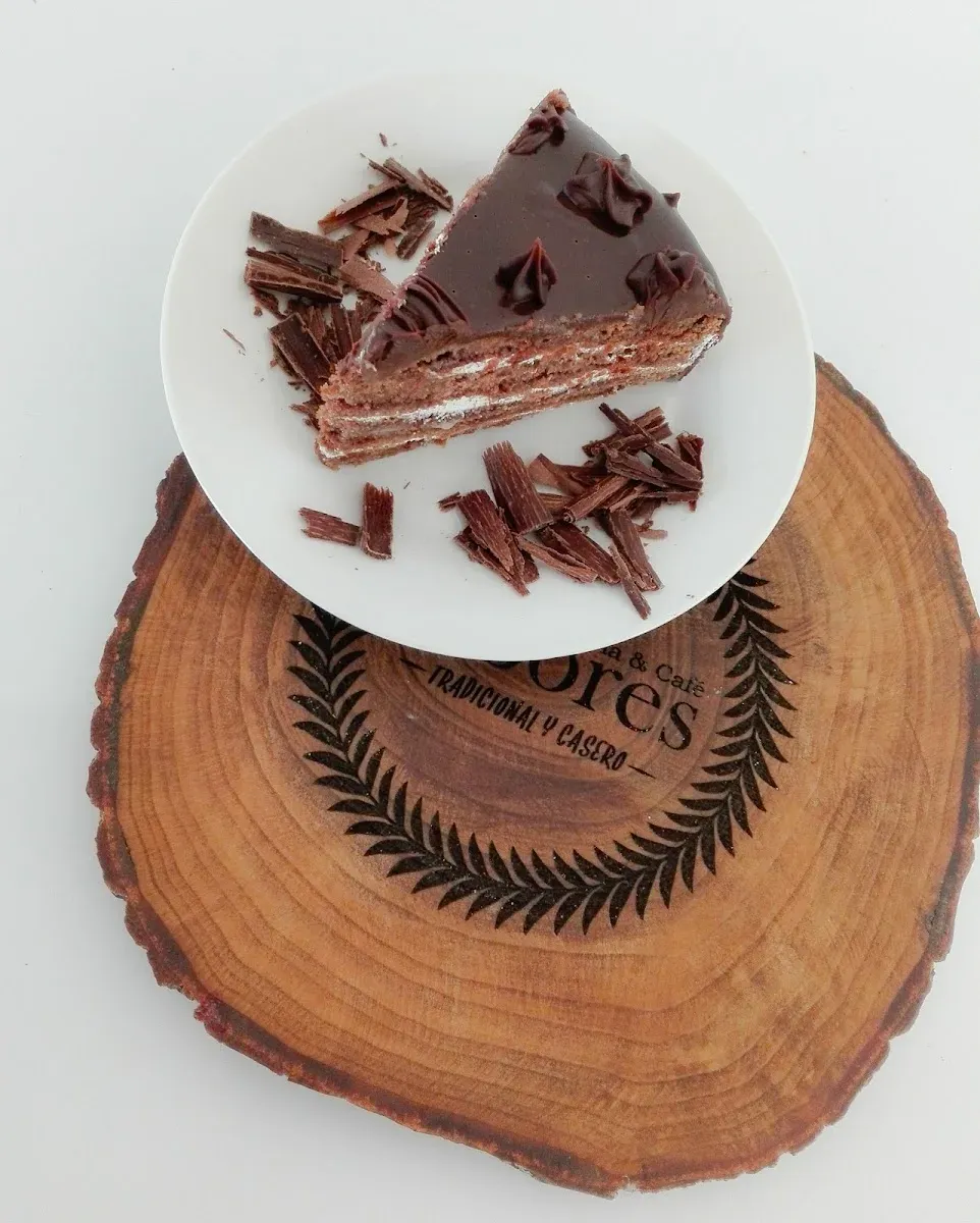 Trozo de torta servido sobre la rodaja de madera grabada de Sabores Tradicional y Casero