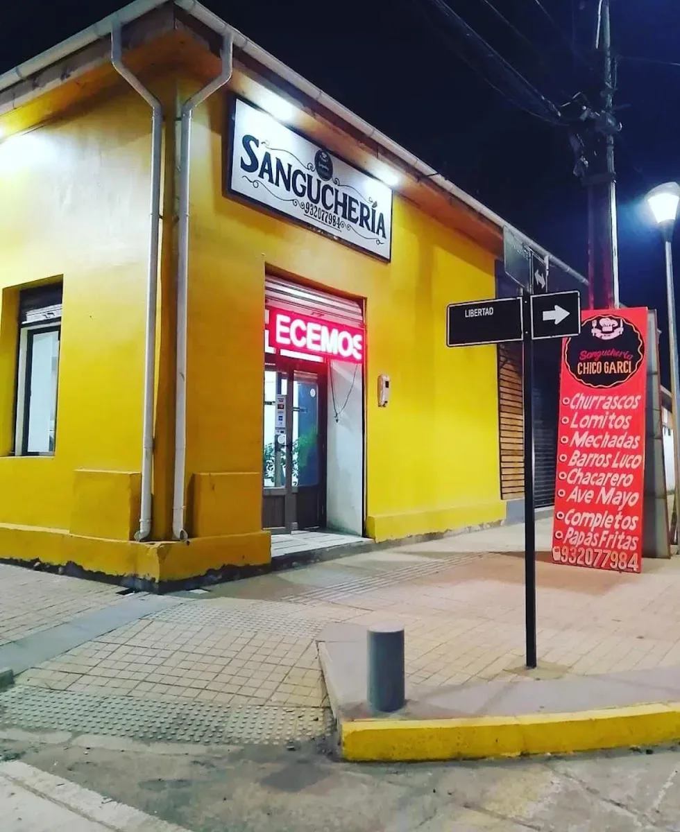 Frontis amarillo de la sanguchería encendido de noche