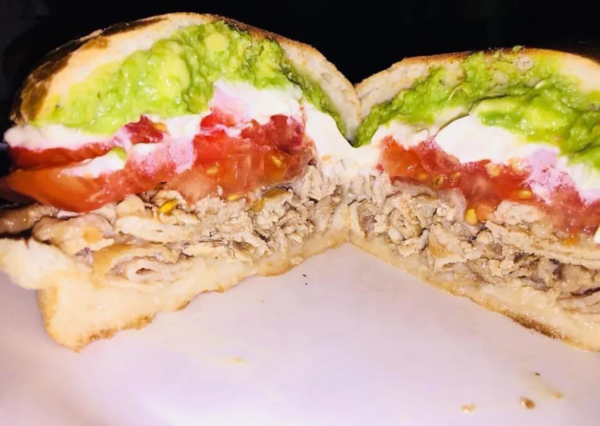 Sándwich de mechada cortado al medio mostrando el relleno