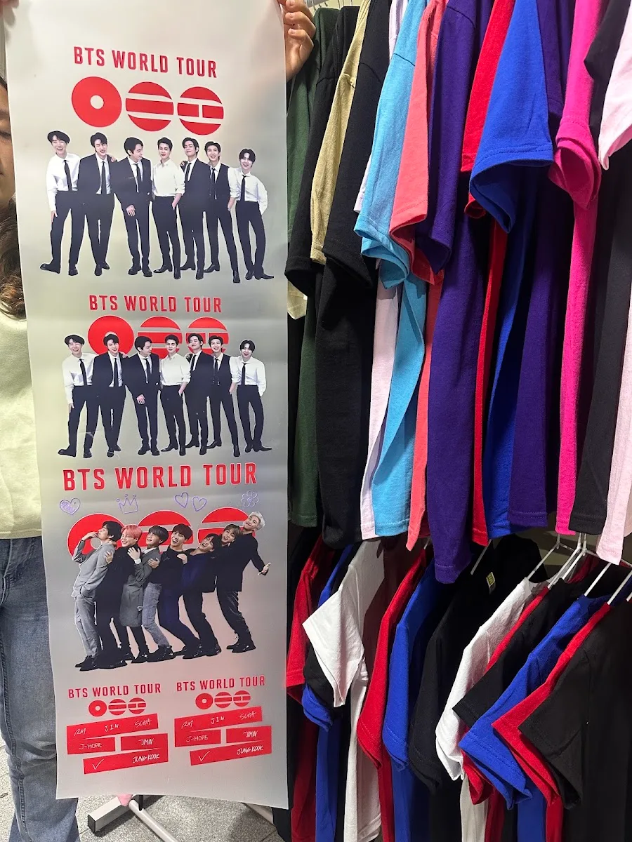 Plancha de estampados DTF listos para transferir junto al rack de poleras de colores