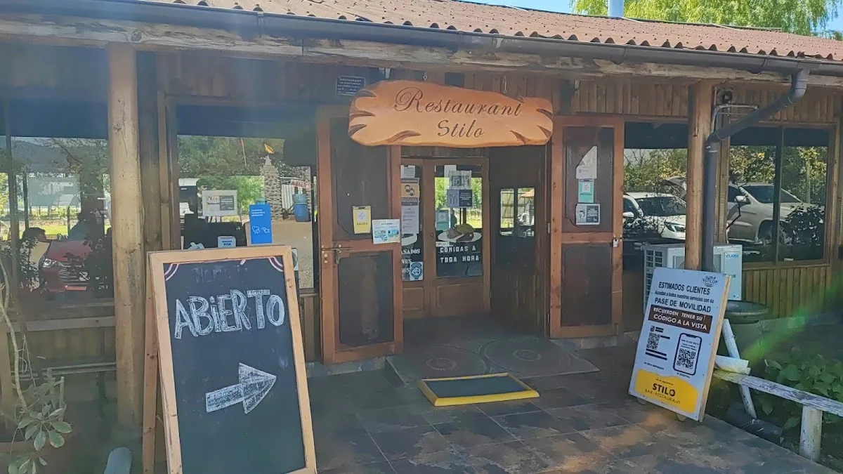 Fachada de madera de Stilo Restaurant con su letrero tallado y letrero abierto, a la orilla de la Ruta K-16 en Sagrada Familia