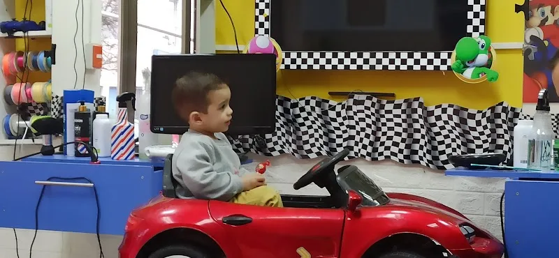 Niño en silla-auto roja mirando sus dibujos en la pantalla