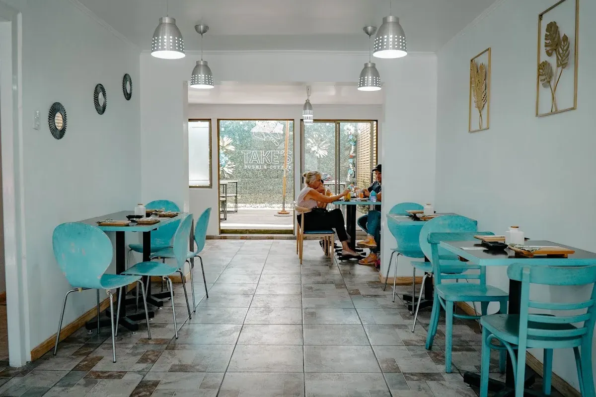 Interior de Take’s con mesas y sillas turquesa