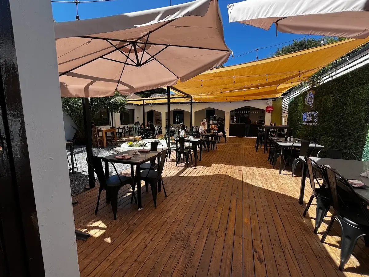 Terraza de madera de Take's con quitasoles y mesas