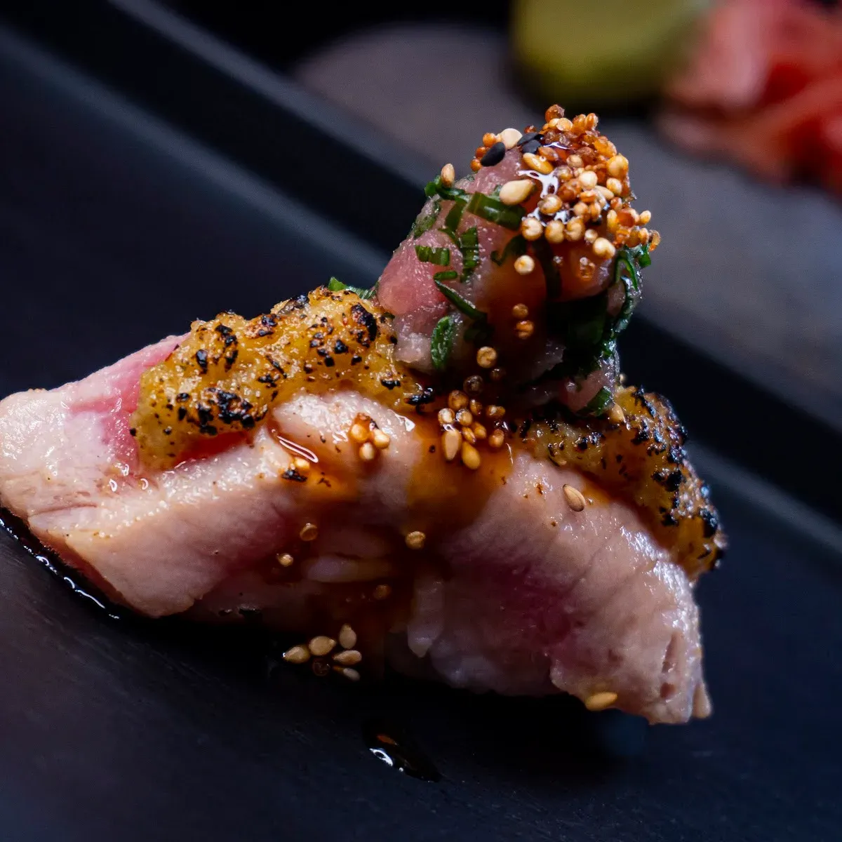 Nigiri flameado con sésamo y salsa en TAKU NIKKEI