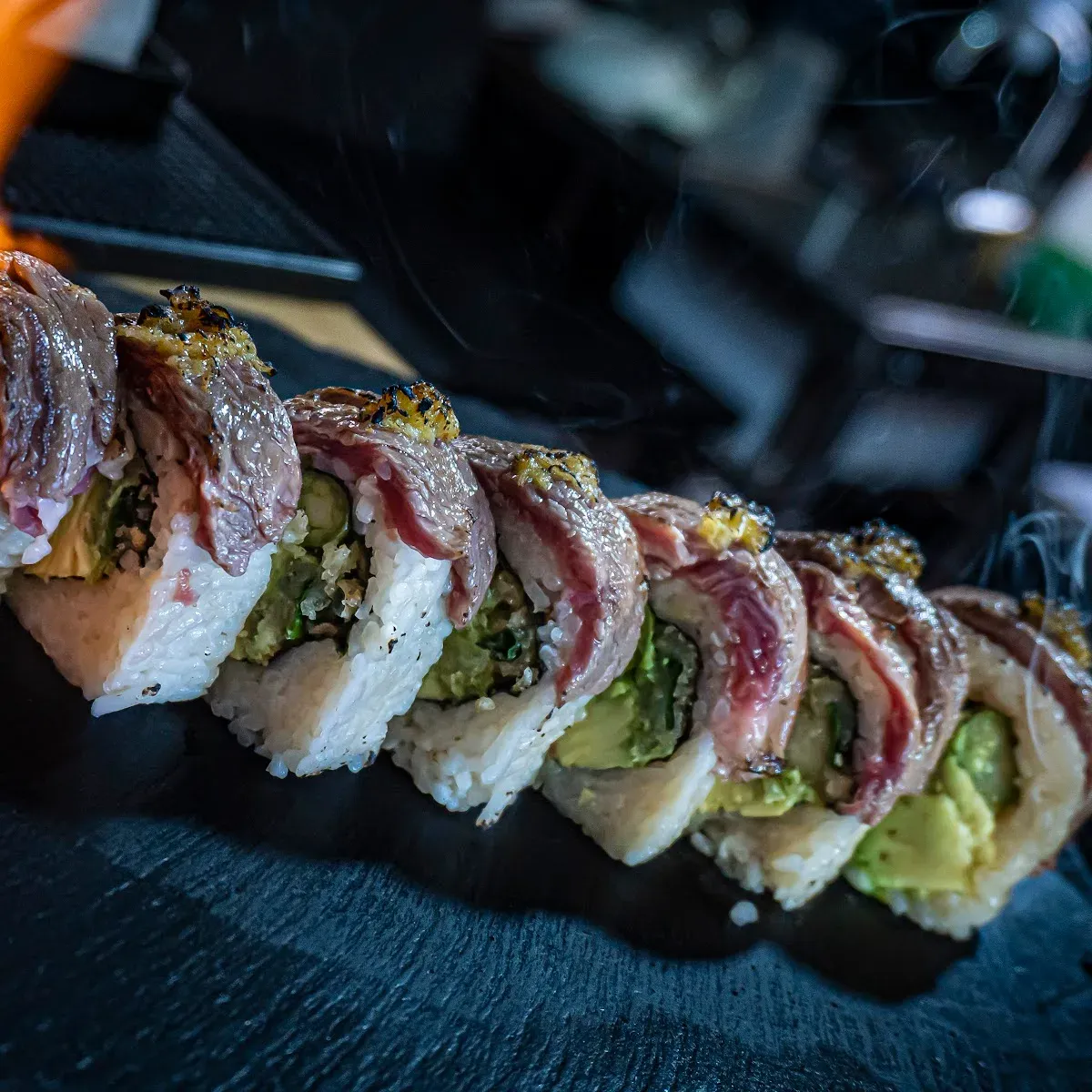 Fila de rolls acevichados servidos en TAKU NIKKEI