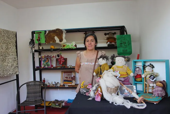 Laura Ramos junto a sus muñecas tejidas en su taller de Itahue