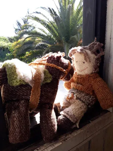 Muñeca y caballo tejidos a mano en la ventana del taller de Itahue