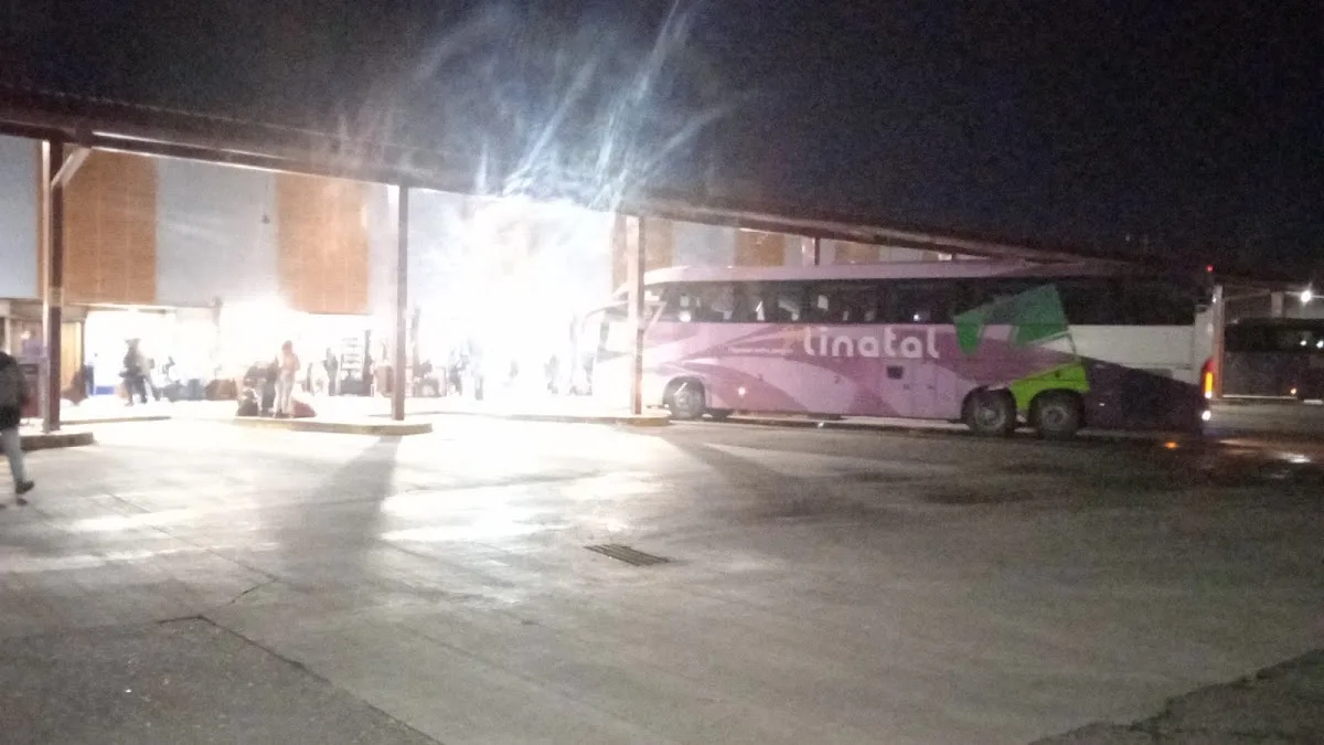 Concurso de pasajeros con equipaje frente a locales y puestos del terminal