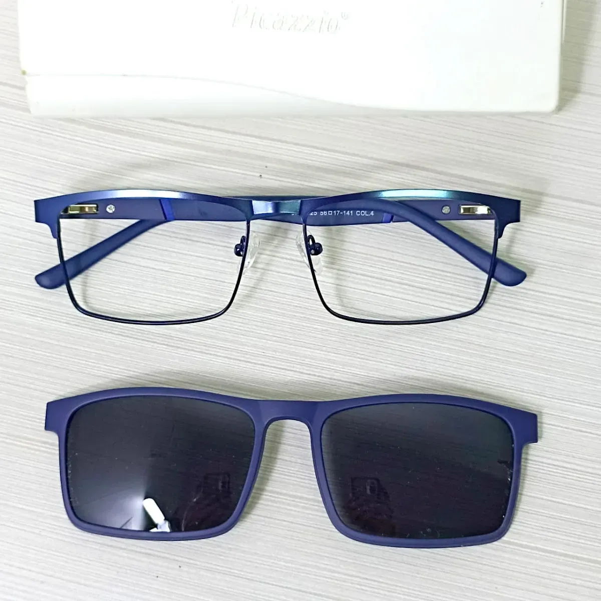 Armazón azul junto a sus lentes de sol a juego