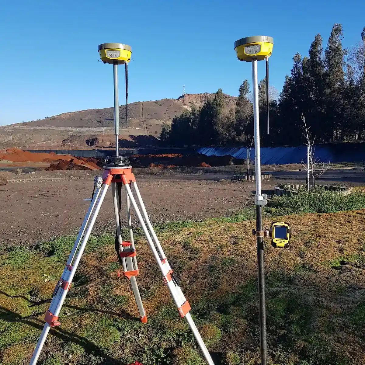 Antenas GNSS instaladas en terreno sobre trípode y bastón durante un levantamiento