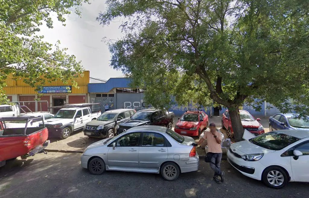 Calle 5 Sur frente al galpón del taller, con camiones y autos del barrio, Talca