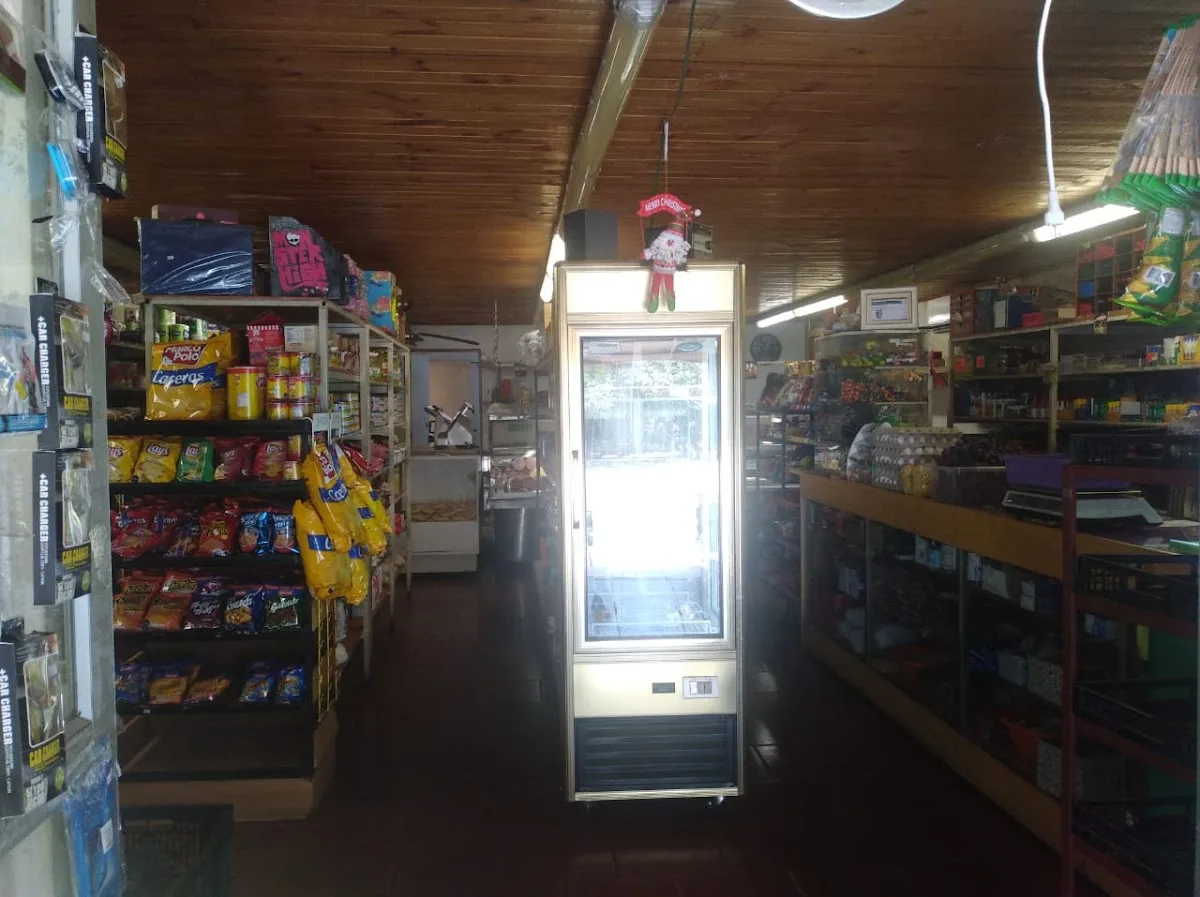 Pasillo interior del Minimarket Unicasa con refrigerador