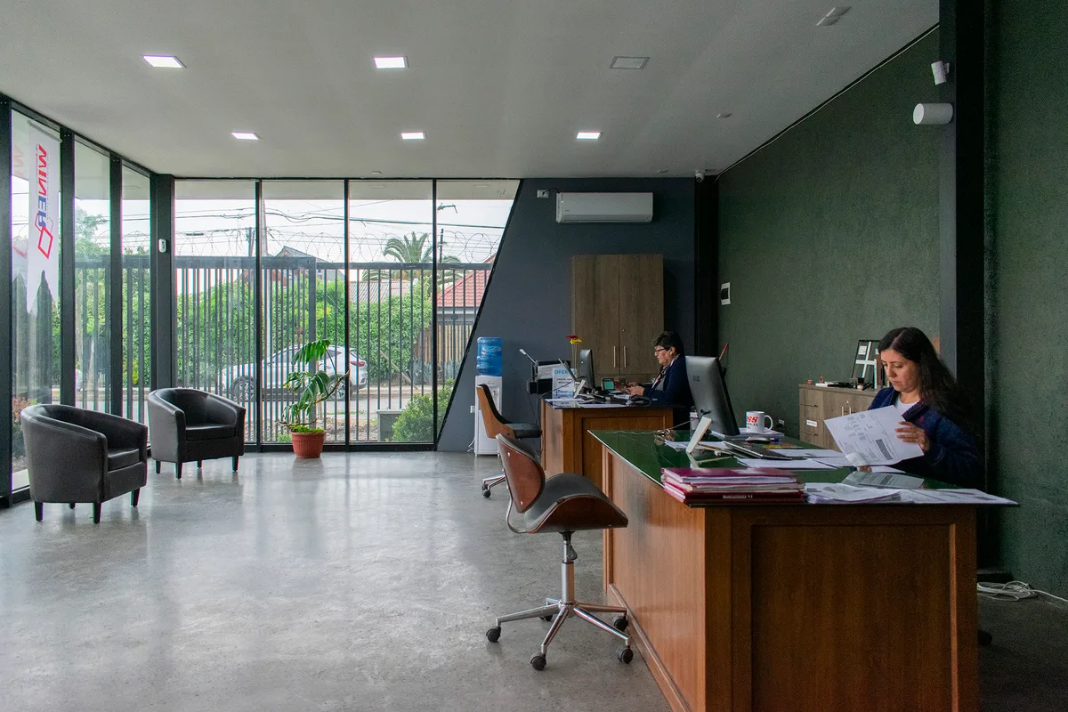 Interior del showroom de INVERLUM con ventanales de aluminio negro de piso a cielo