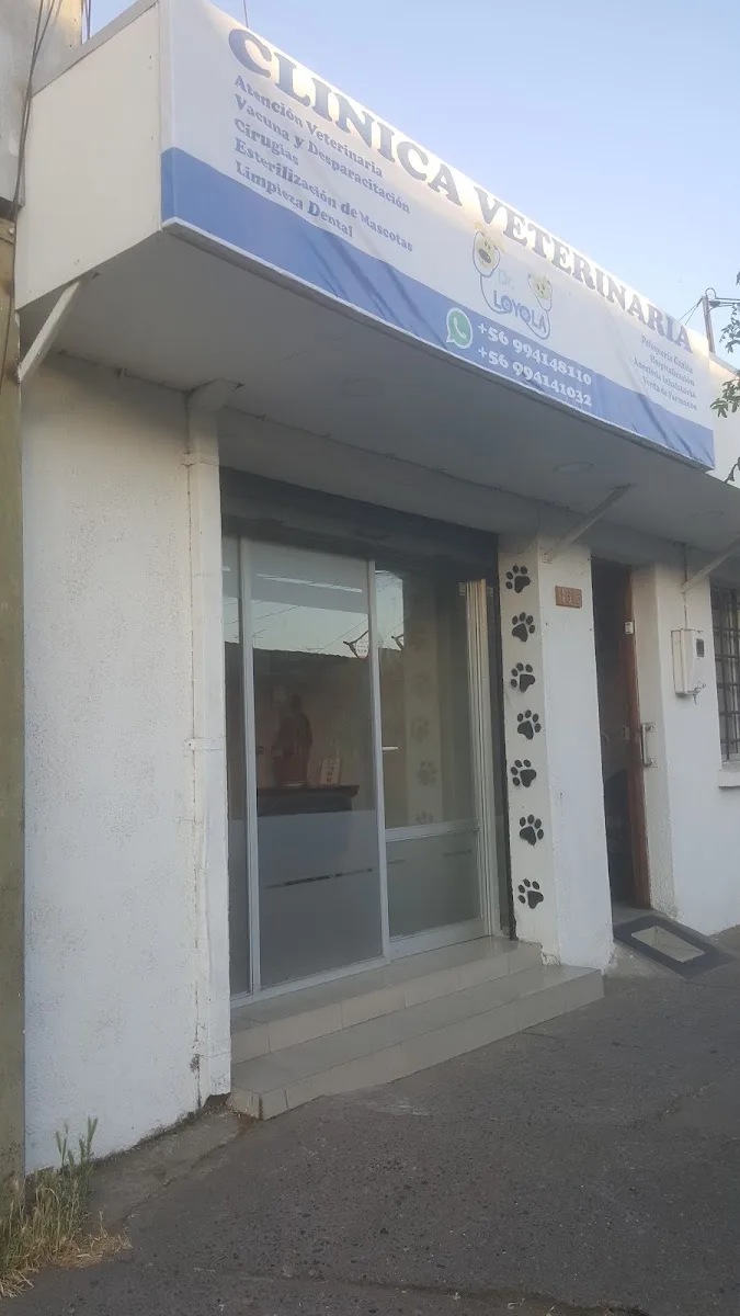 Entrada de la veterinaria con el letrero azul y las huellas en el pilar