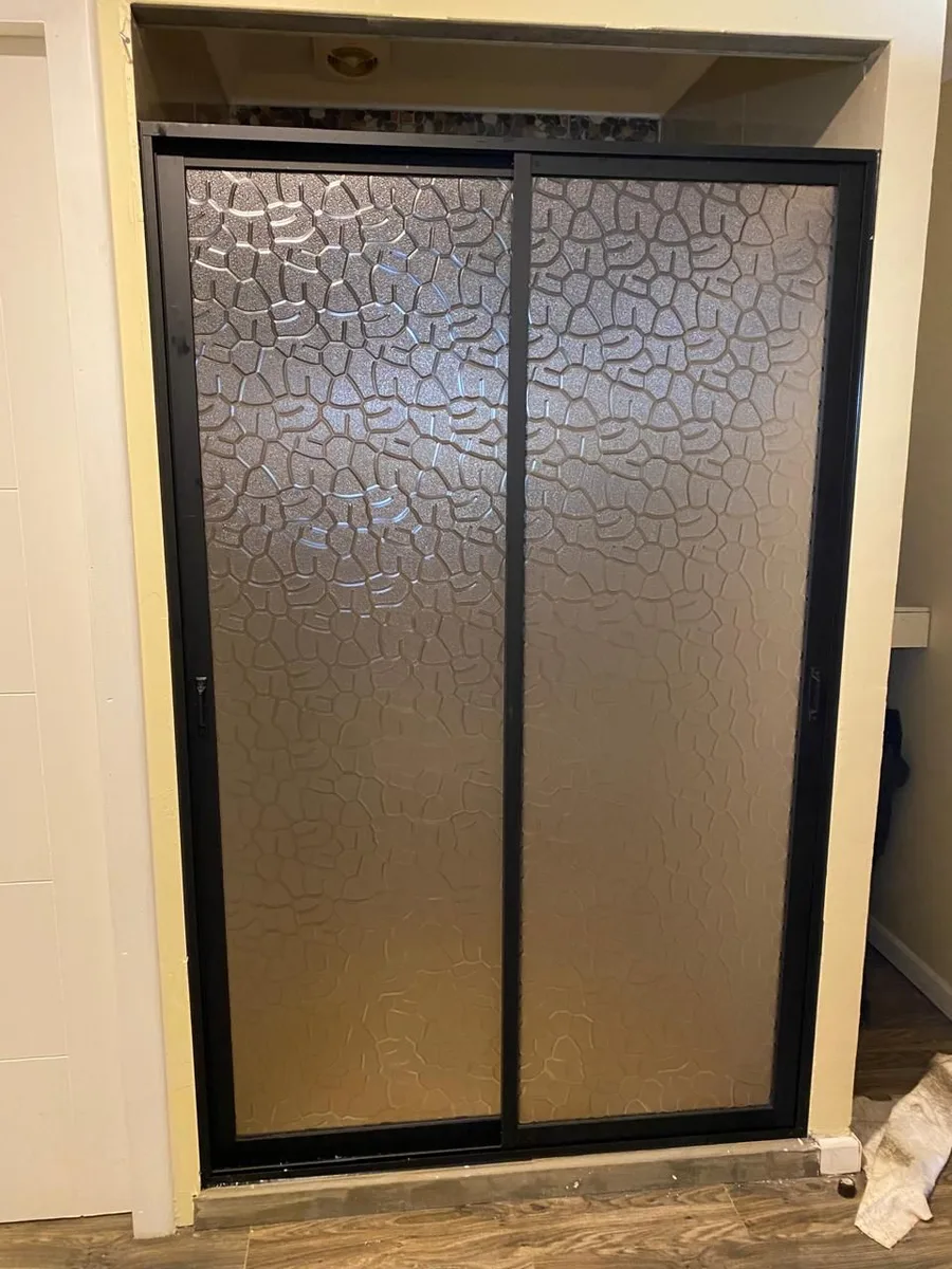 Puerta de aluminio bronce con vidrio texturizado