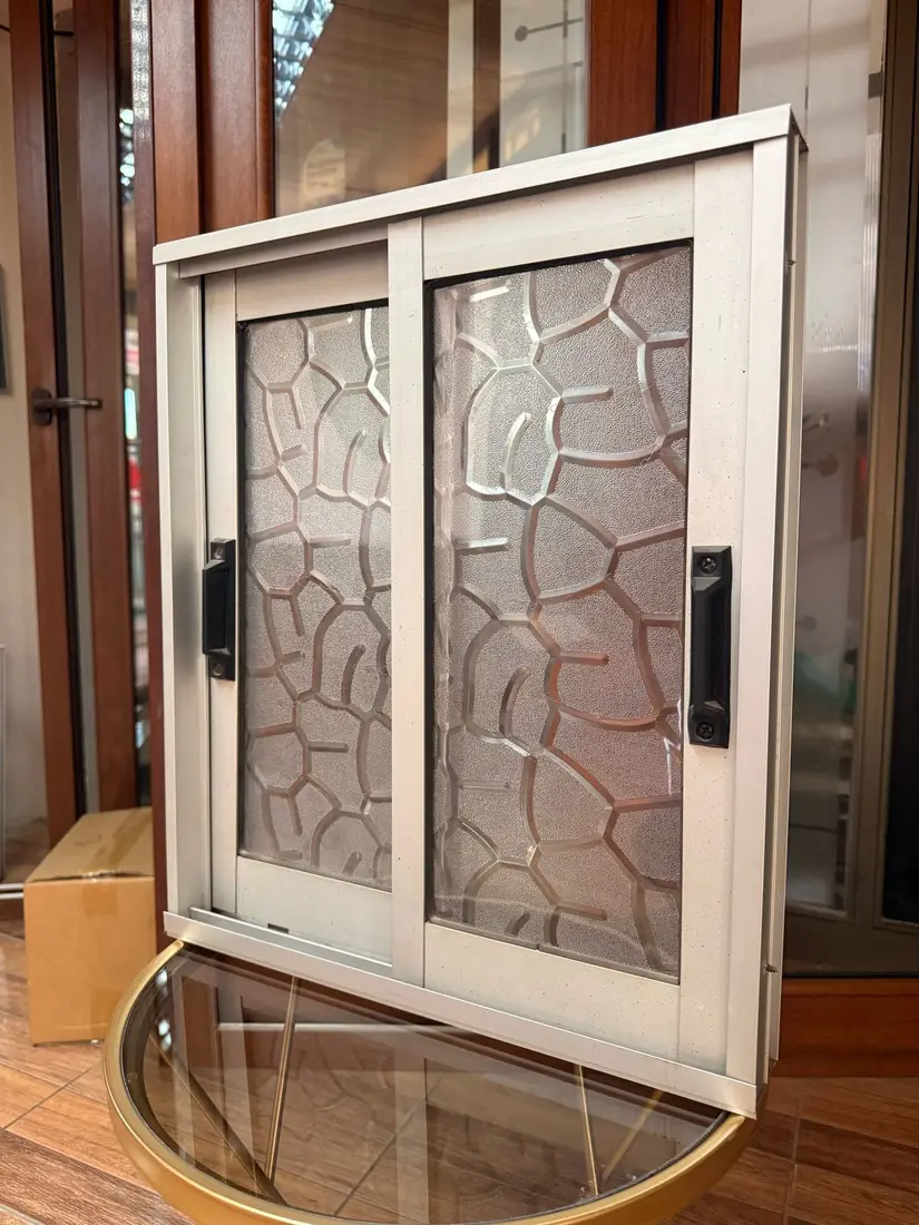 Ventana PVC blanca con vidrio decorativo en exhibición