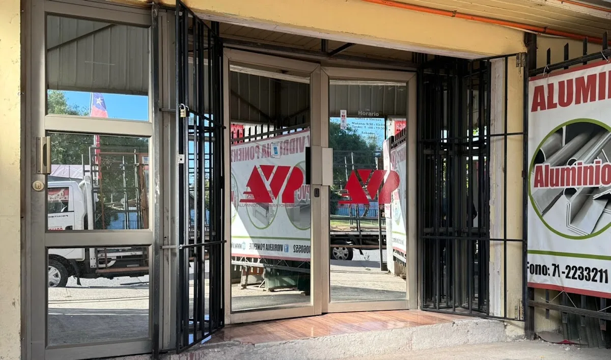 Entrada del local con puertas plegables de aluminio y vidrio