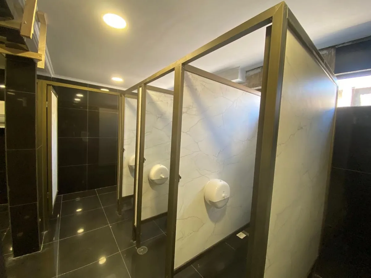 Divisores de baño en aluminio color bronce expuestos en la tienda