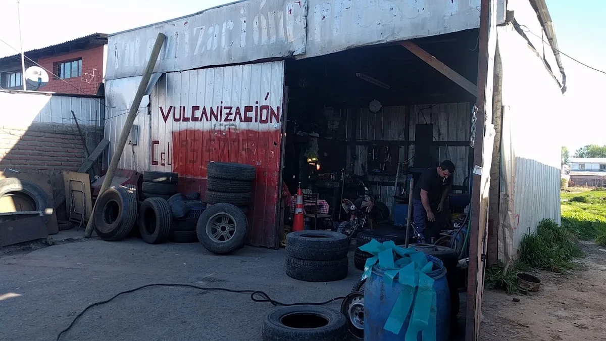 Fachada de Vulcanización Lontué: letrero rojo pintado a mano sobre la lata del galpón y neumáticos apilados en la entrada