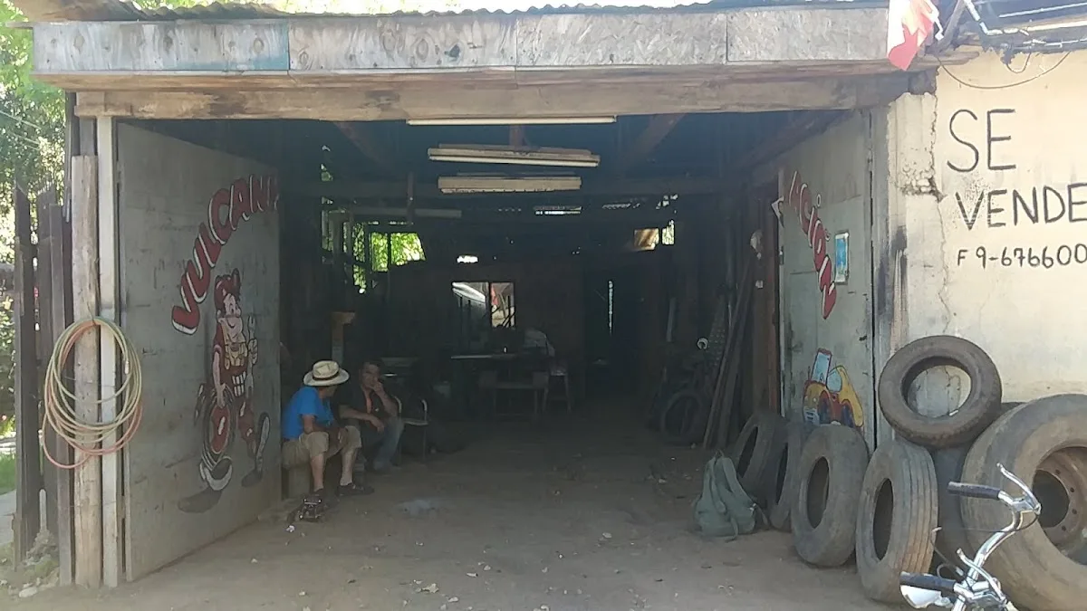 Portones abiertos del taller de Vulcanización Lontué con neumáticos apilados y el letrero pintado a mano