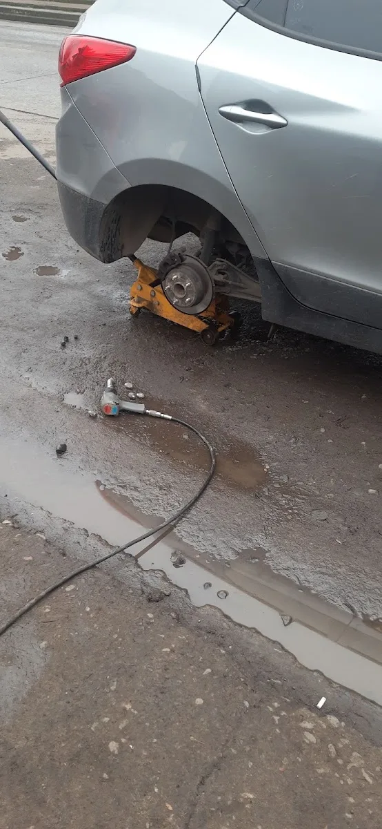 Auto sobre la gata en Vulcanización Lontué con la pistola de impacto lista para desmontar la rueda