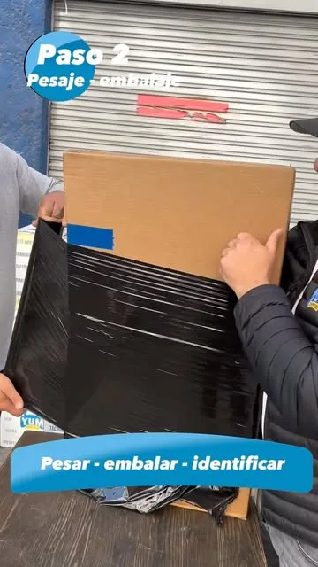 Manos embalando una caja con cinta de Yum Express